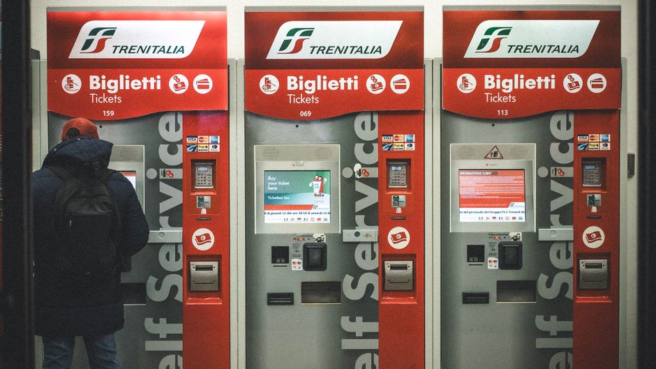 A traveler uses Trenitalia ticket machines at a station in Florence, Italy.